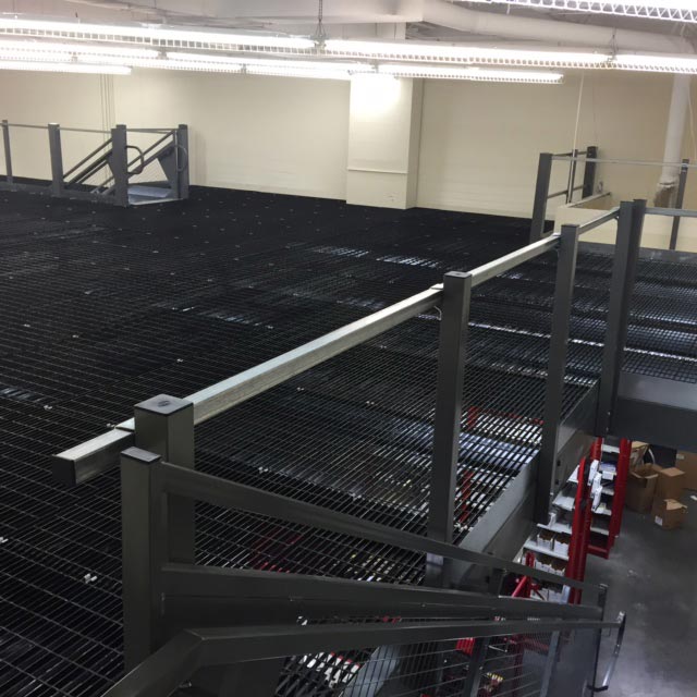 Finished grate decking. Mezzanine work platform installed above auto parts storage shelving units - Dallas TX