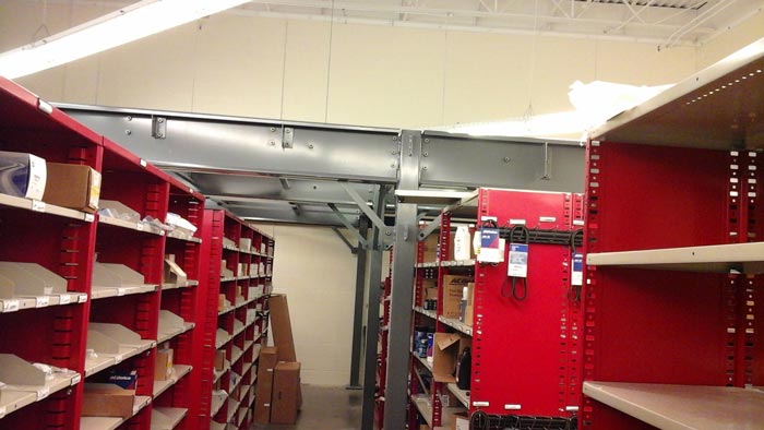 Mezzanine work platform installed over existing automotive parts storage shelving units - Dallas TX